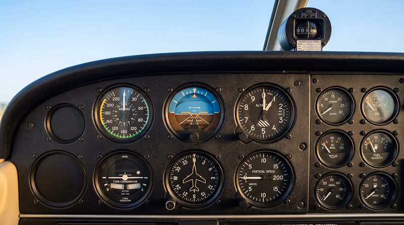 A clean illustration of a single-engine aircraft instrument panel showing the six-pack arrangement of flight instruments with each gauge clearly visible and labeled