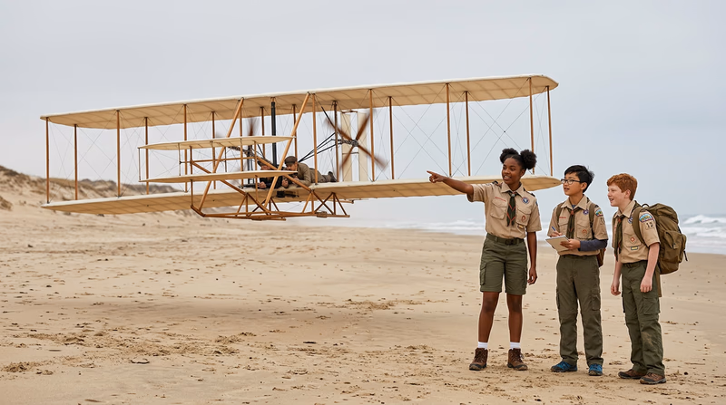 An illustration of the Wright Flyer in the air at Kitty Hawk with sand dunes in the background, rendered in a historical style
