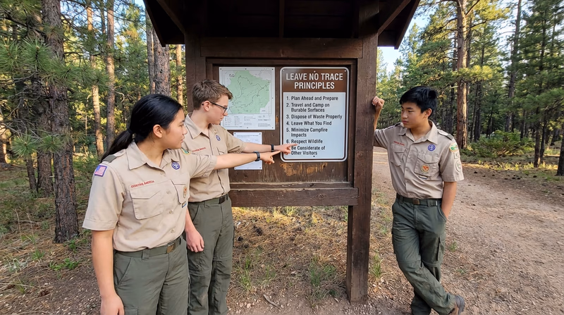 A trail sign at a wilderness boundary showing Leave No Trace principles on a wooden kiosk
